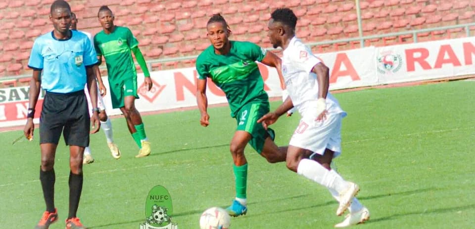 Enugu Rangers player dribbling against Bendel Insurance