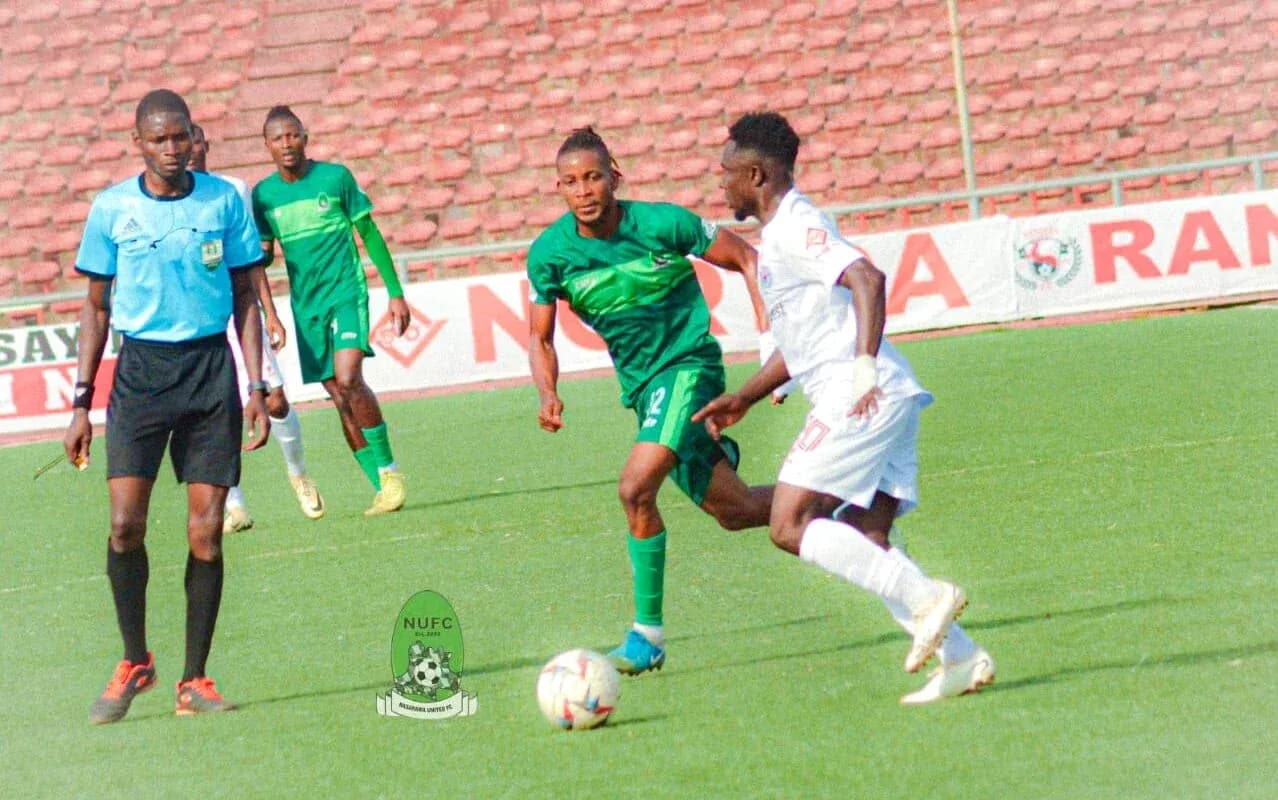 Enugu Rangers player dribbling against Bendel Insurance