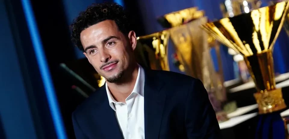 Player posing with trophies in the background