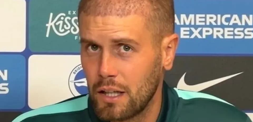 Football manager speaking at press conference podium