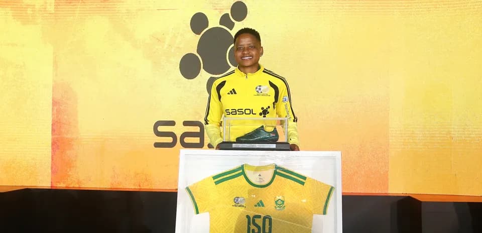 Player holding a trophy and jersey at event