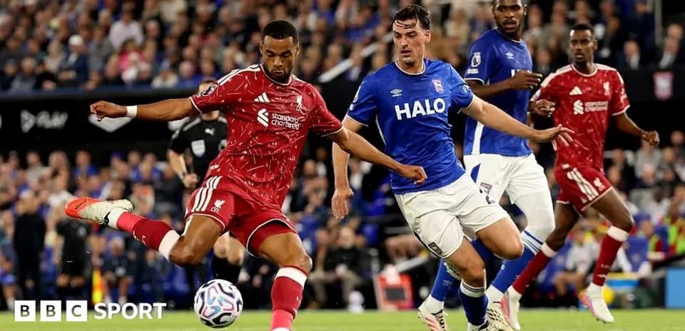 Liverpool player kicking the ball against Ipswich defenders