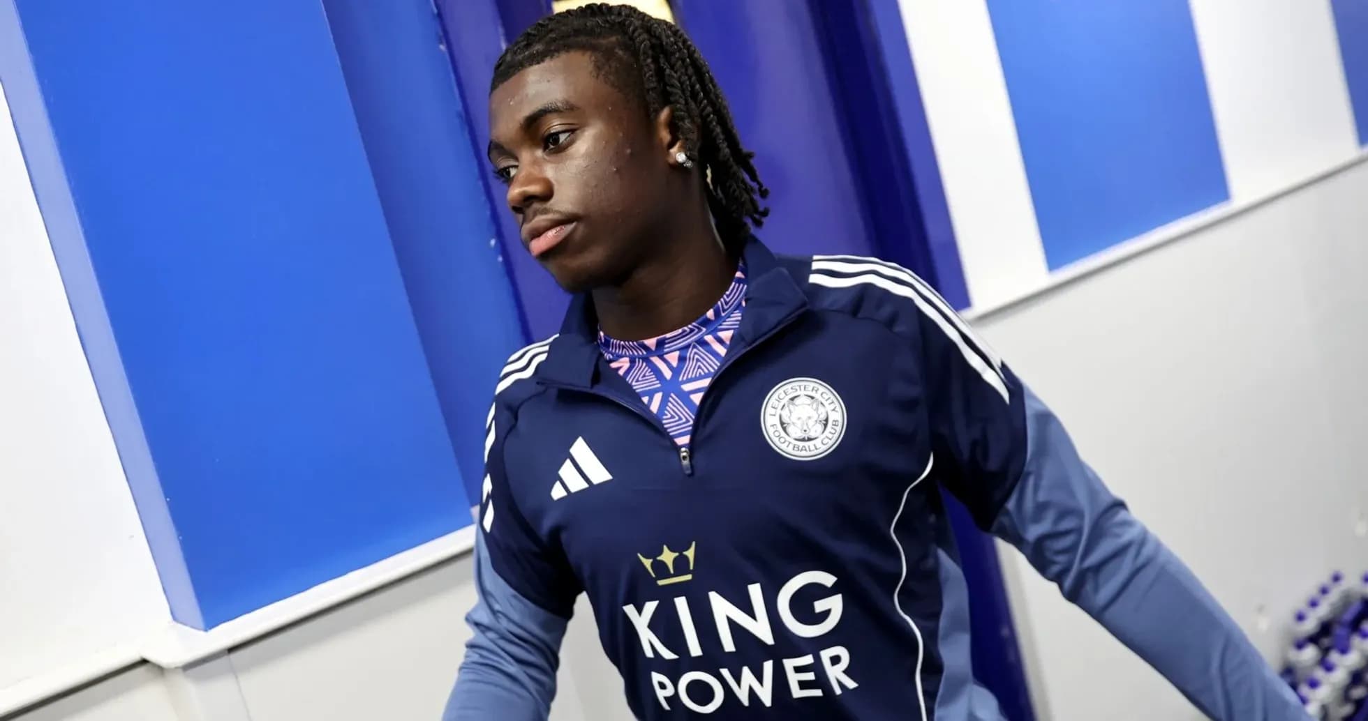 Player entering the locker room wearing Leicester City gear