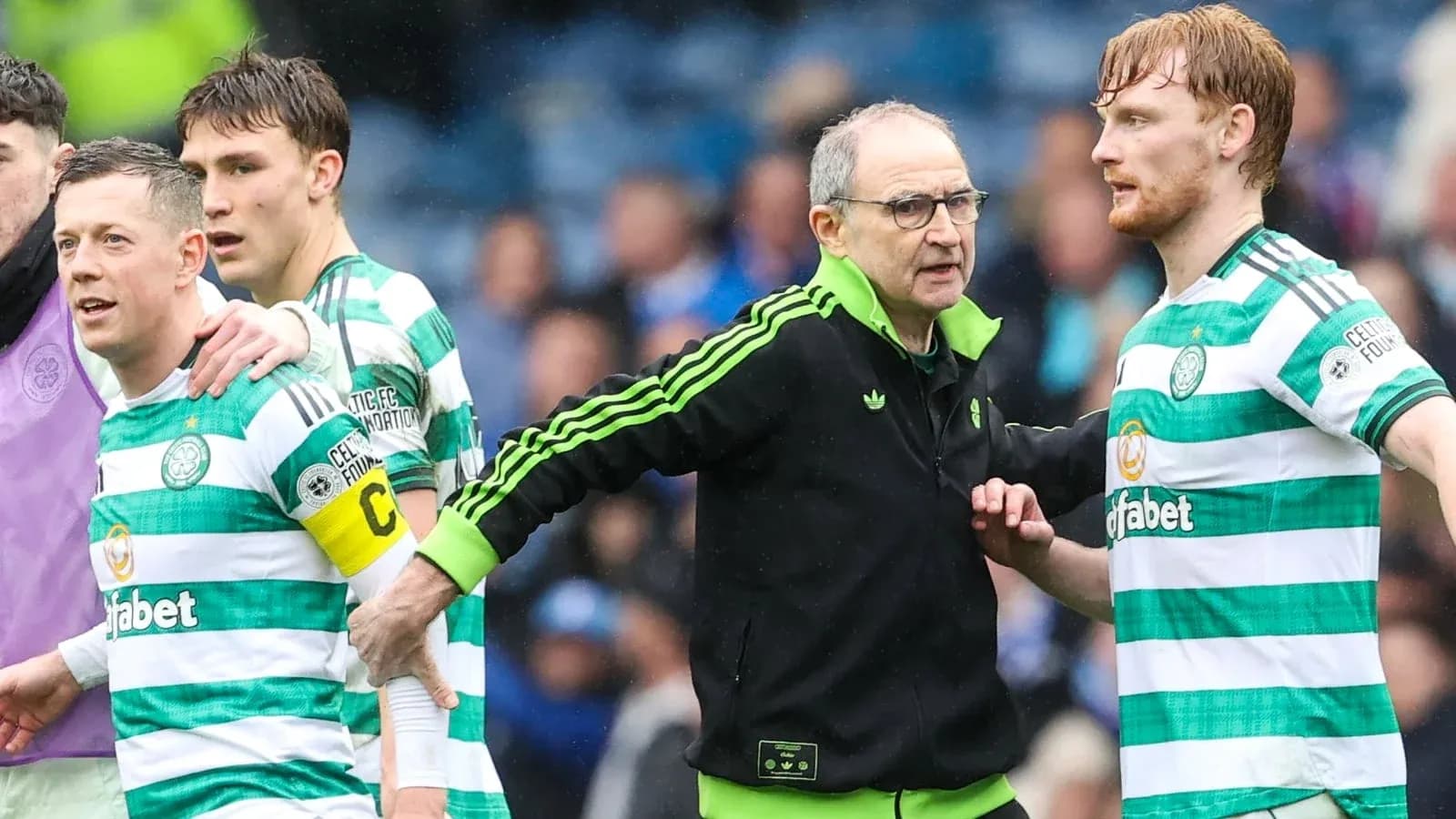 Celtic players and coach interacting on the pitch