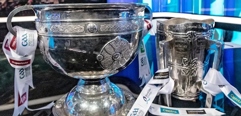 Two silver trophies with ribbons displayed together