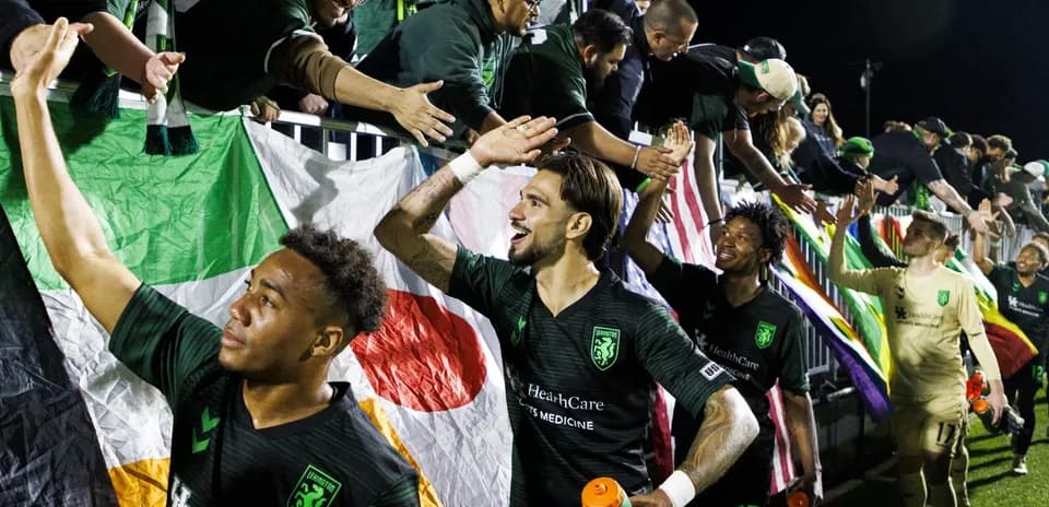 Players celebrating with fans after the match