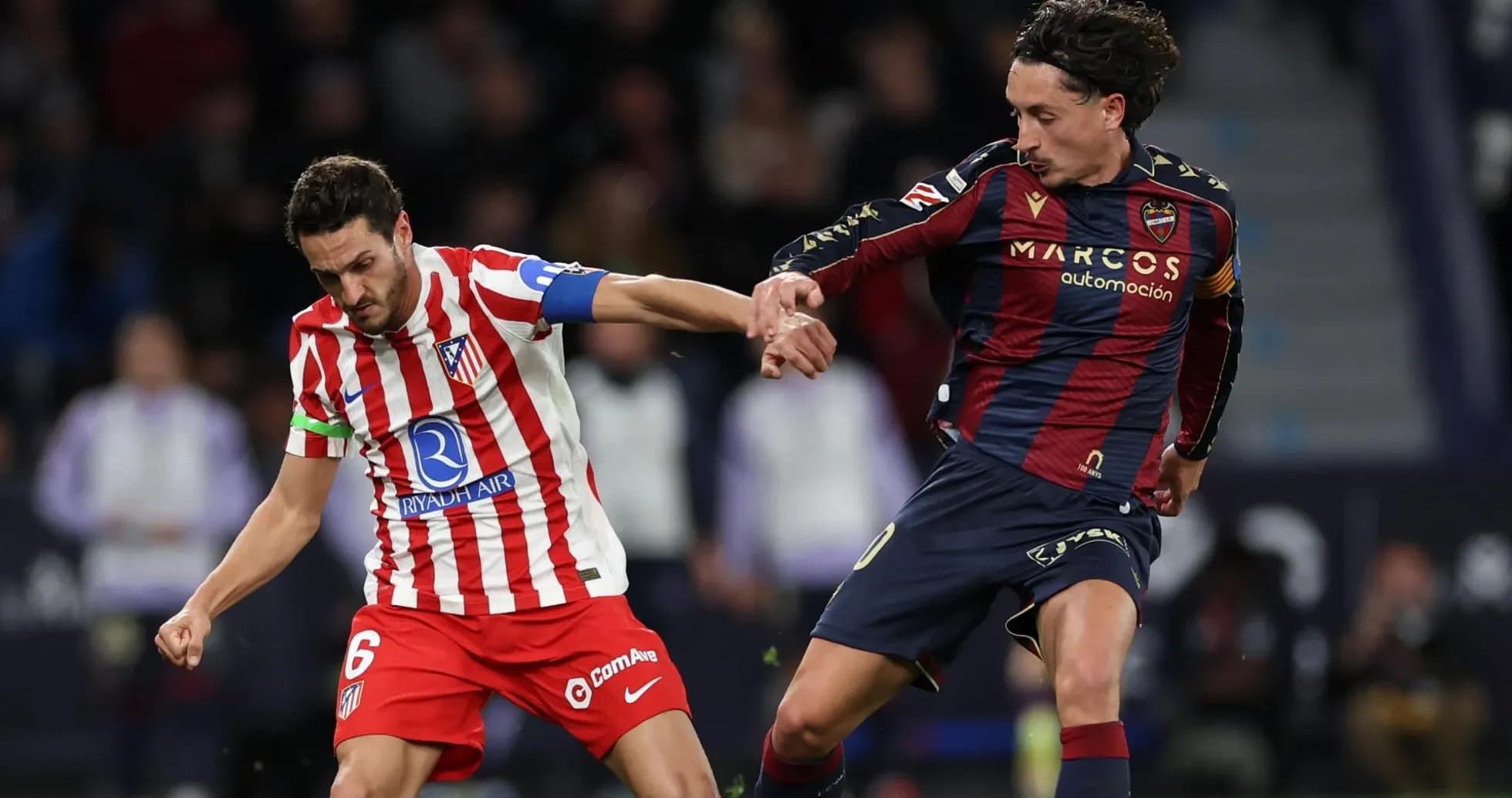 Atletico Madrid player challenging Levante opponent