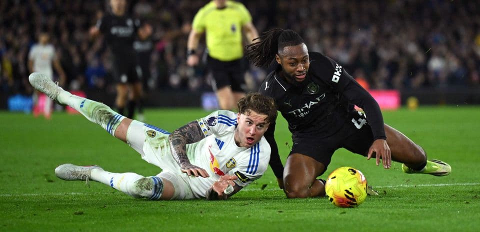 Leeds player tackling Manchester City opponent