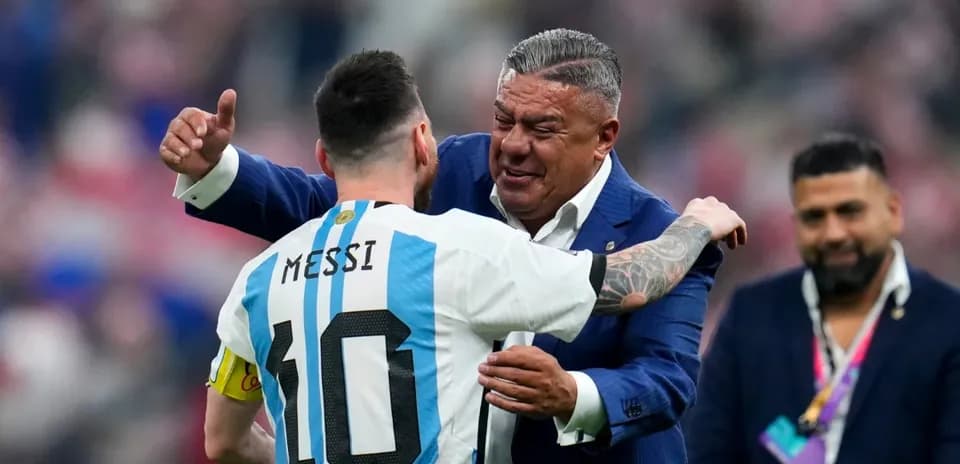Lionel Messi hugging a man in a suit