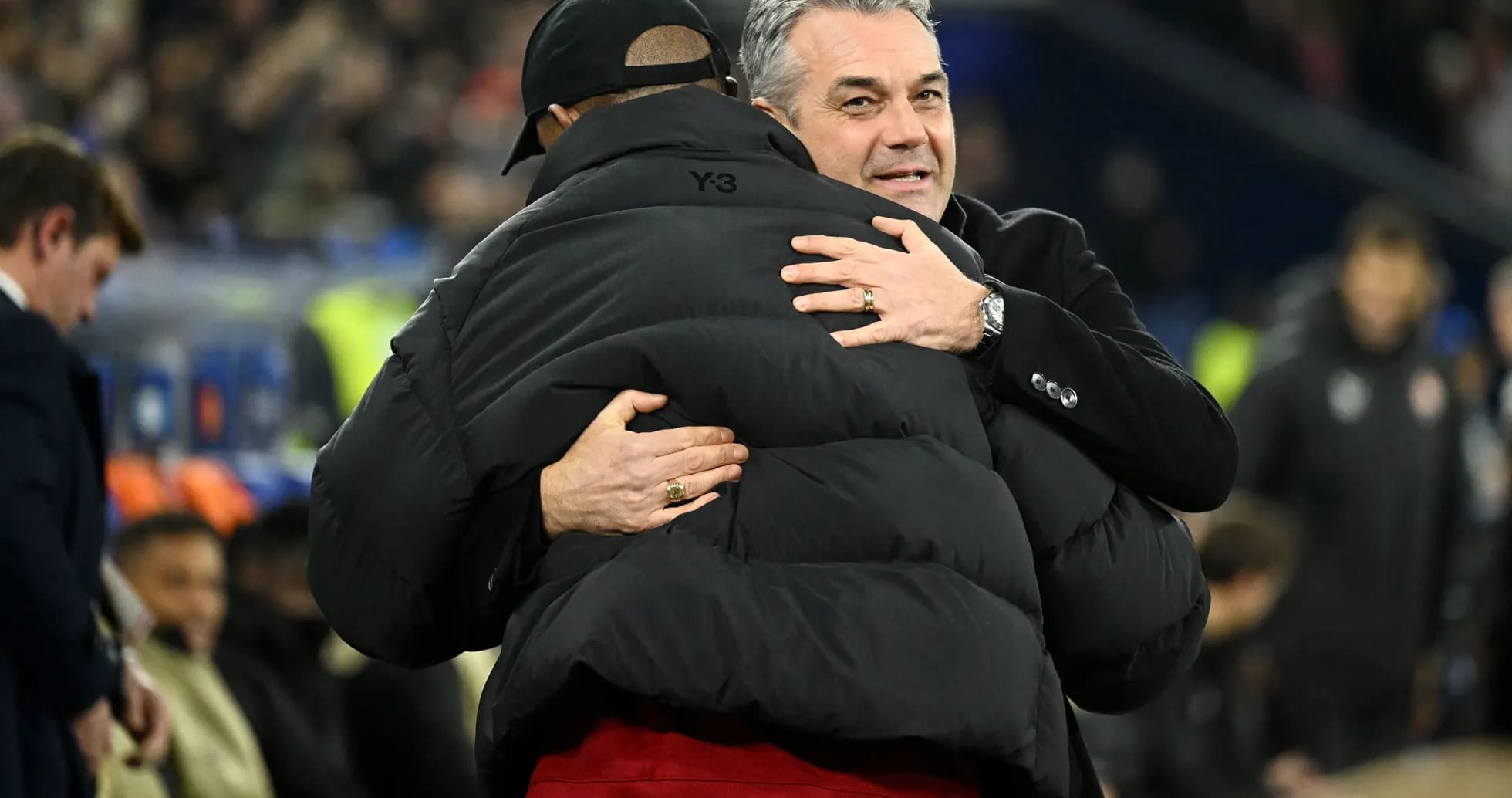 Two coaches embracing on the sidelines