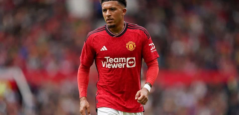 Player in Manchester United kit walking on pitch