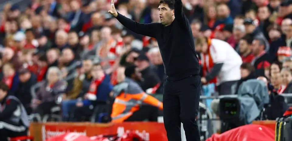 Coach gesturing during a football match on the sidelines