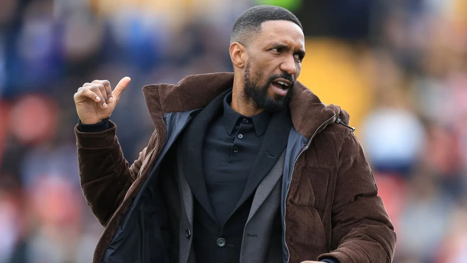 Coach gesturing on the sideline during match