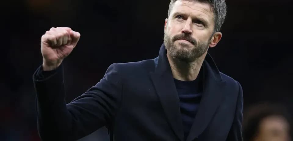 Coach celebrating with a raised fist on the pitch