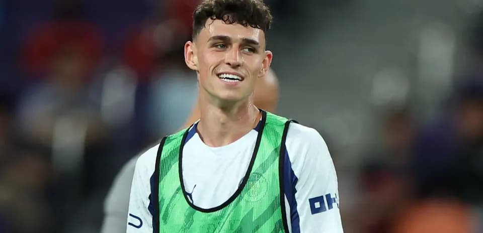 Player wearing training bib smiling on the pitch