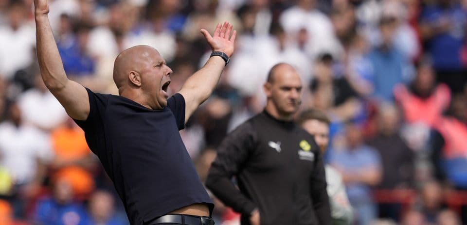 Coach gesturing during match with players in background