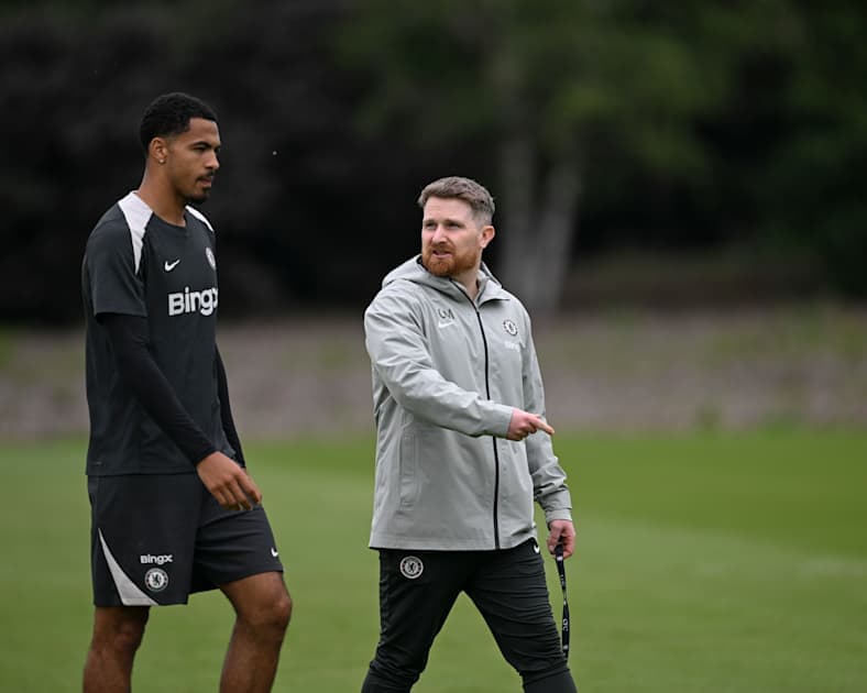 Player and coach walking on training pitch