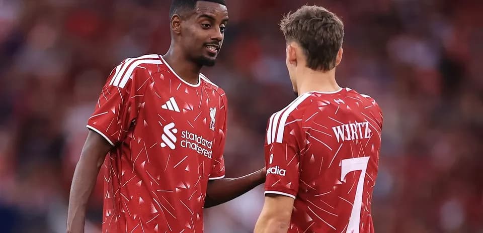 Two Liverpool players discussing on the pitch