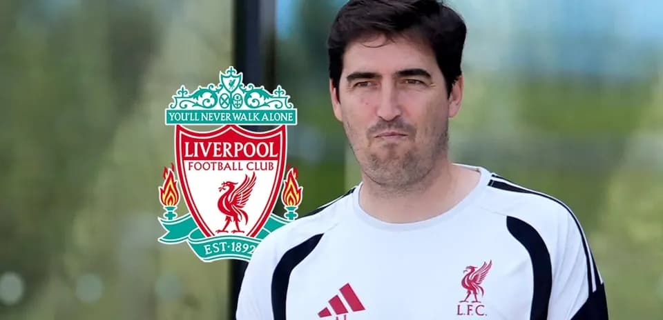 Coach walking past Liverpool FC logo outdoors