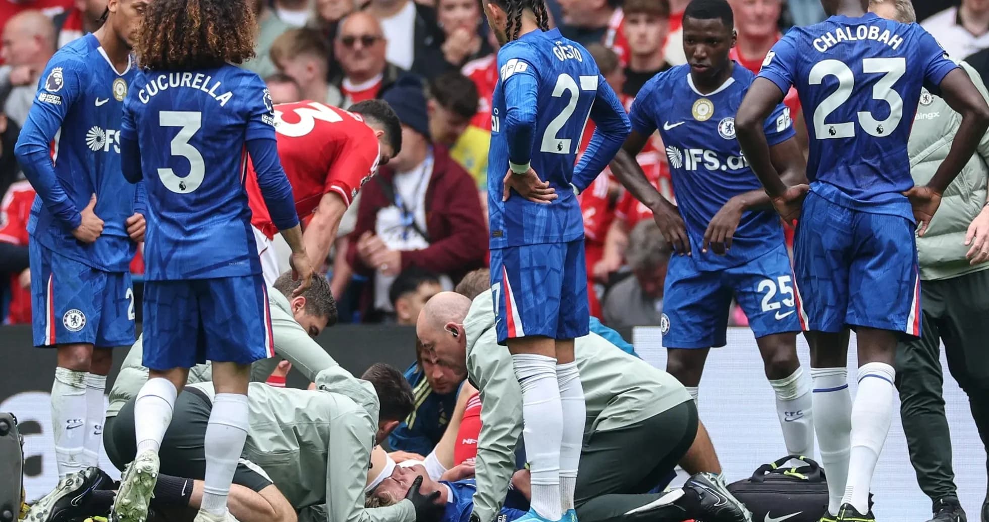 Players gathered around an injured teammate on pitch