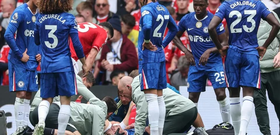 Players gathered around an injured teammate on pitch
