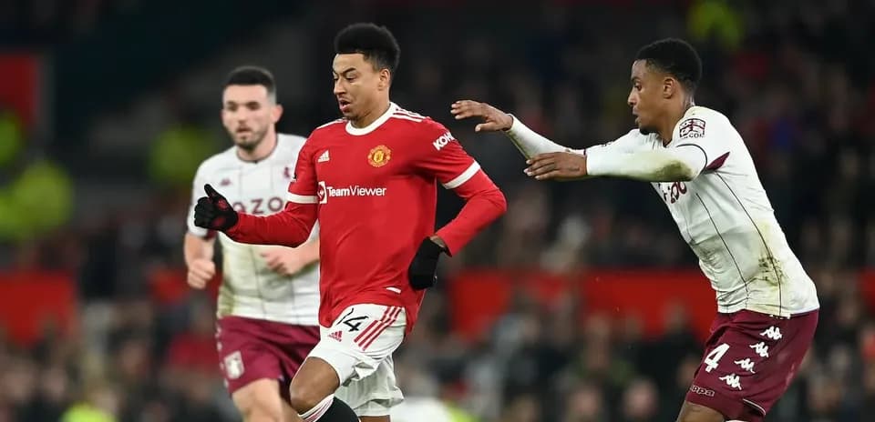 Manchester United player dribbling past Aston Villa opponent