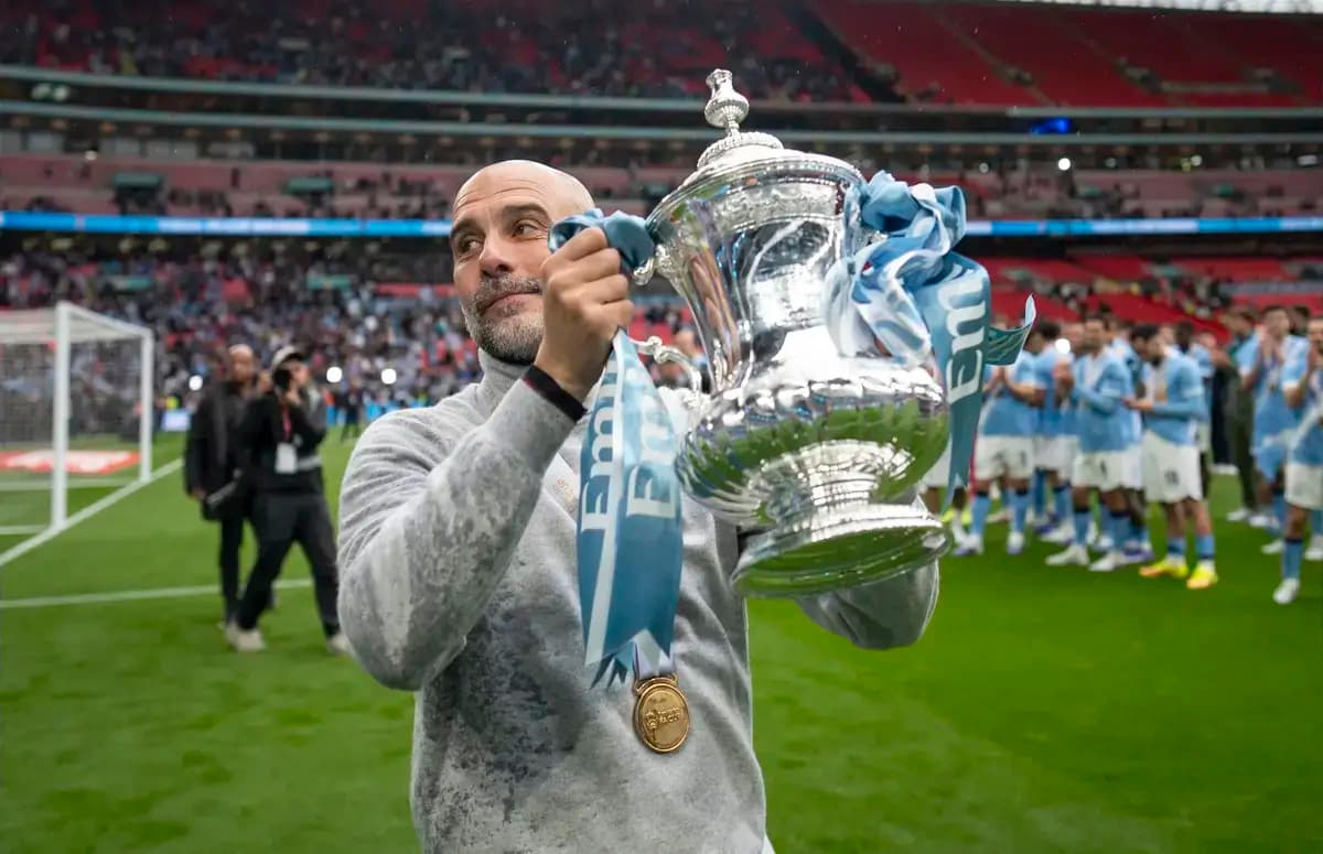 Manager holding trophy on pitch after victory