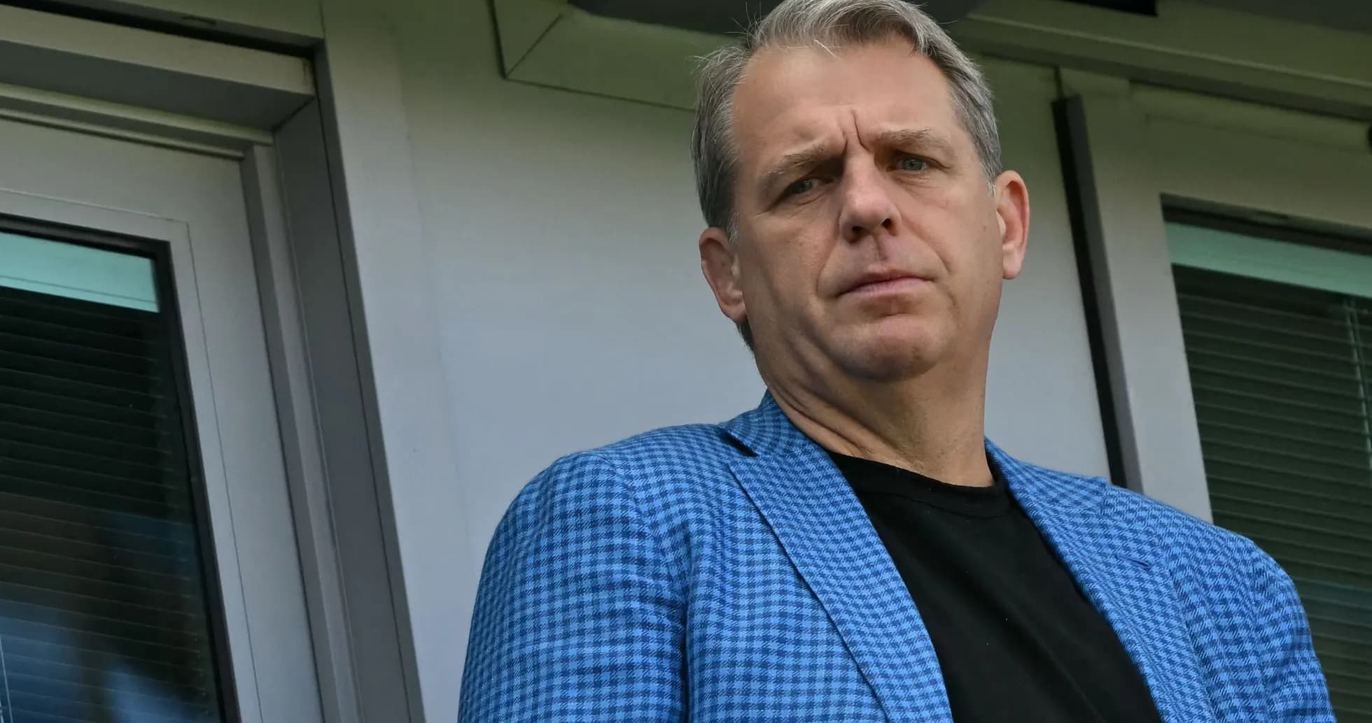 Man in blue blazer looking from a balcony