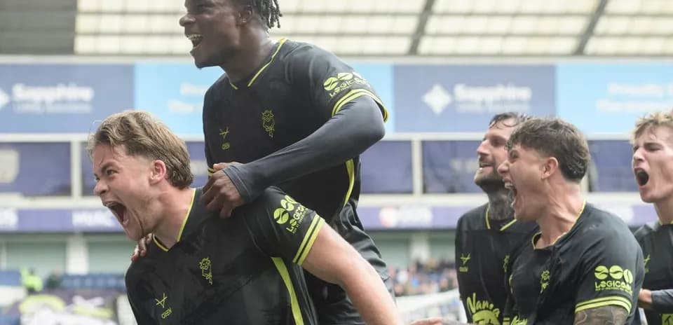 Players celebrating a goal with excitement on field