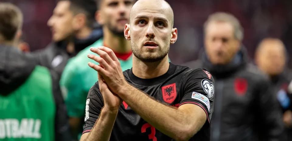 Player applauding after match, wearing Albania jersey