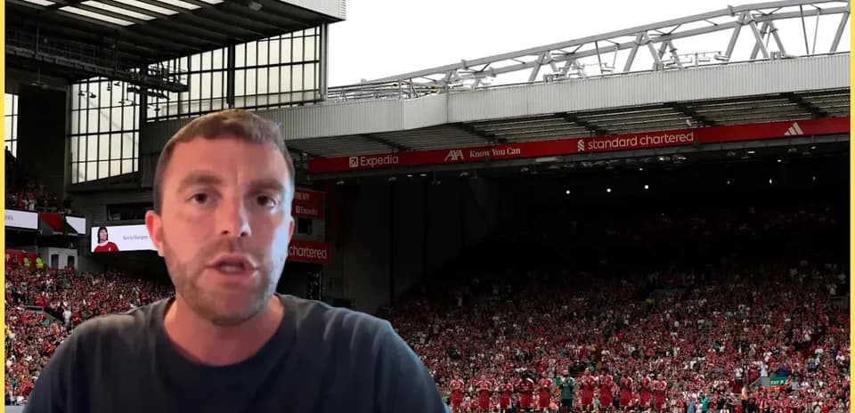 Presenter speaking in front of Anfield stadium crowd