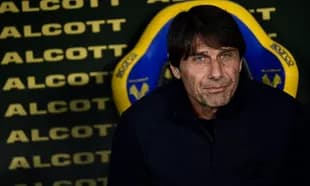 Coach seated on bench during match preparations