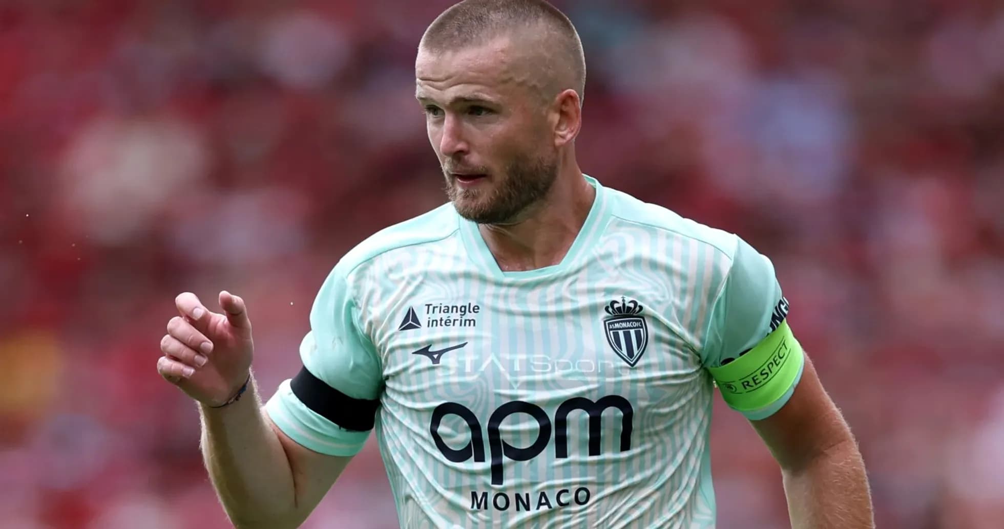 Player in mint jersey with captain's armband during match
