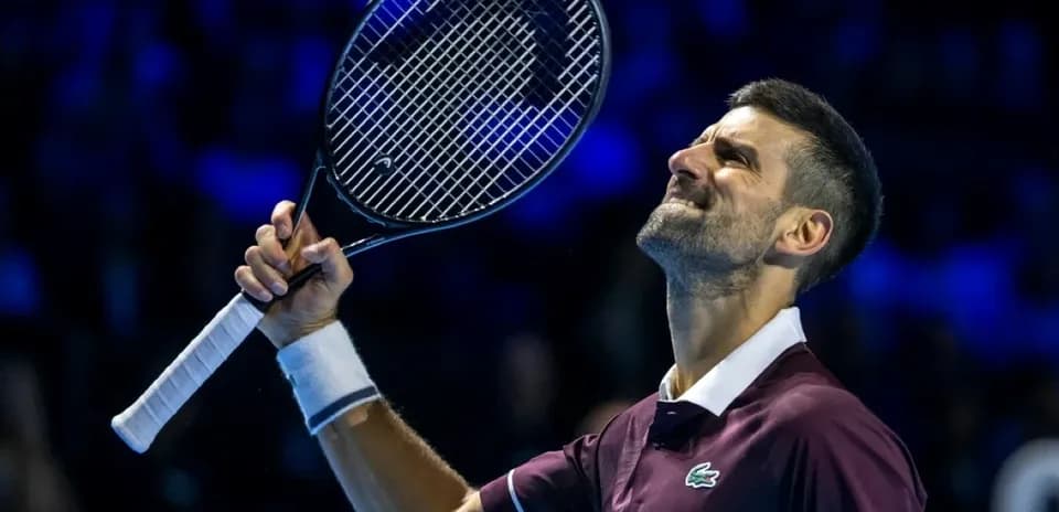 Tennis player celebrating with racket raised after victory