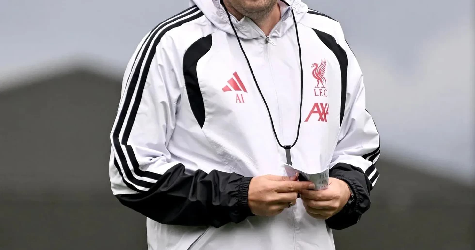 Coach smiling while walking on training pitch