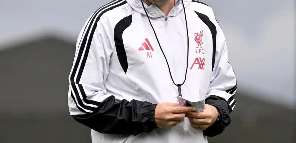 Coach smiling while walking on training pitch