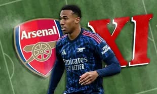 Arsenal player walking in front of club logo