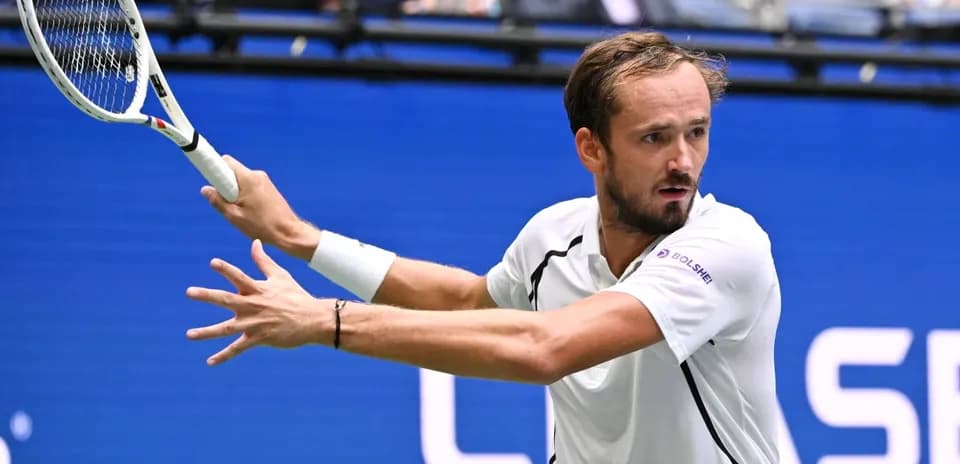 Tennis player hitting a backhand shot during match