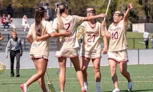 Lacrosse team celebrating a goal on the field
