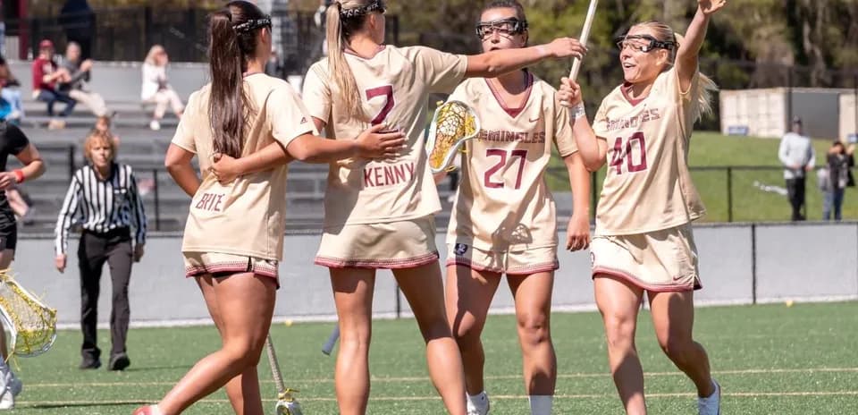 Lacrosse team celebrating a goal on the field