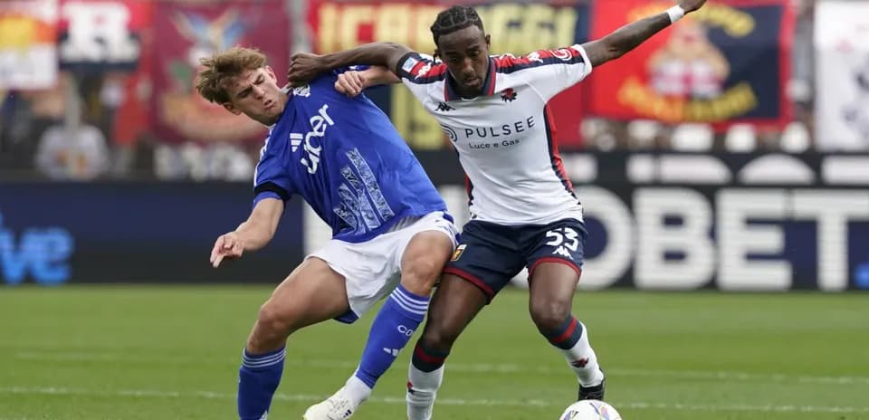 Genoa player tackles Como opponent during match