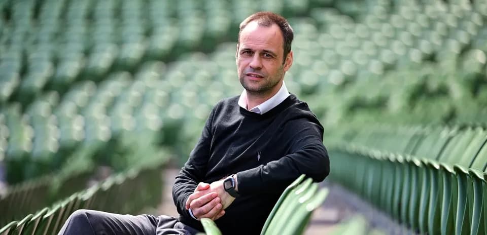 Man sitting on stadium seats, looking at camera