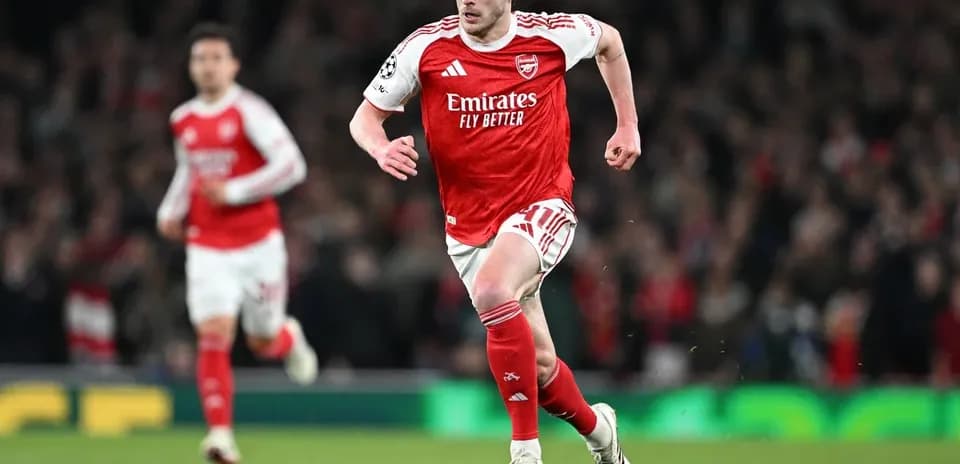 Arsenal player sprinting towards the ball on field