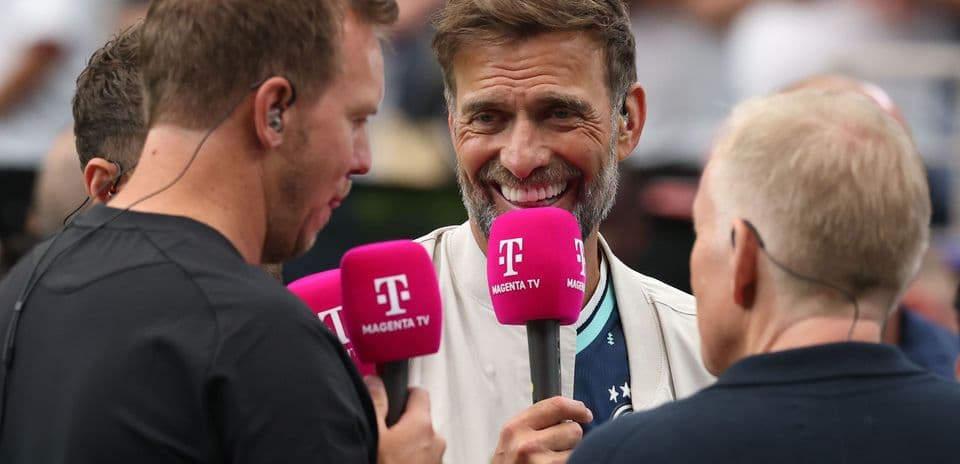 Three men holding microphones during an interview