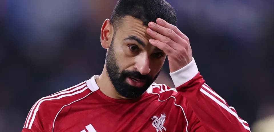 Player in red jersey during match, hand on forehead