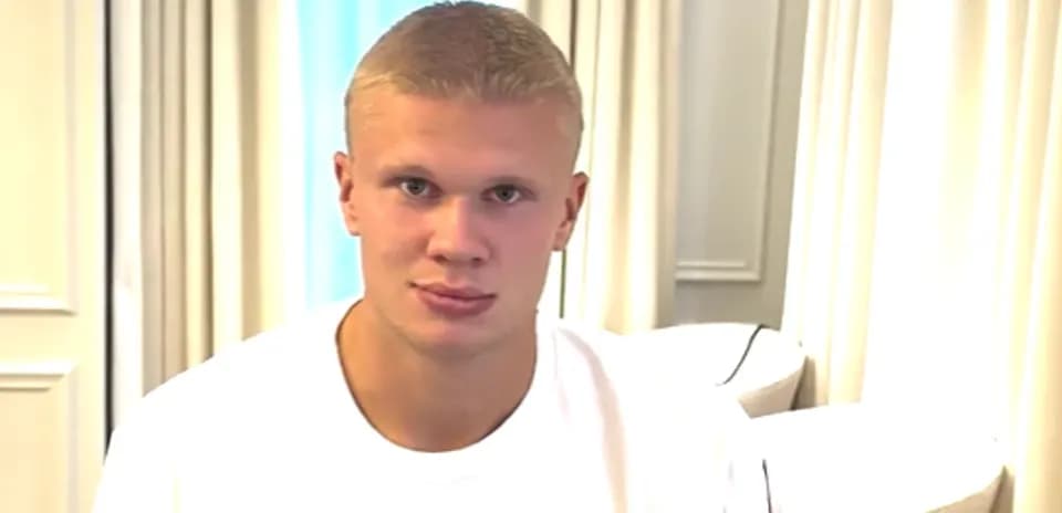 Young man sitting indoors in a white shirt