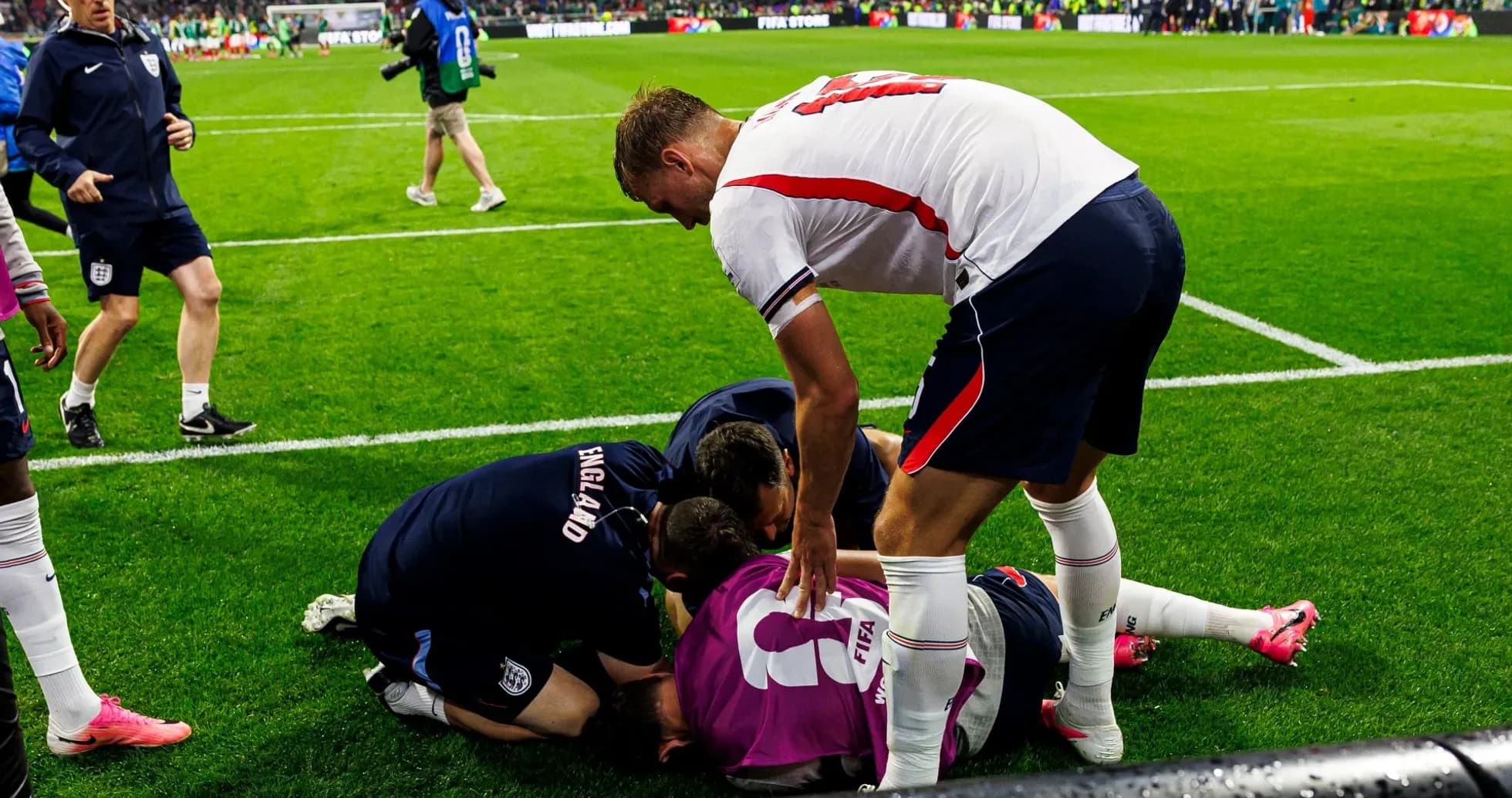 Players and staff attending to injured goalkeeper on field