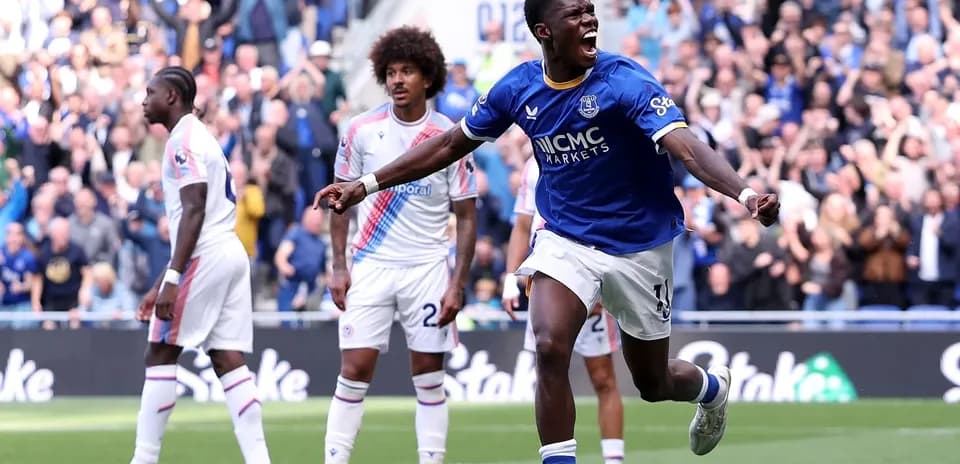 Player celebrating goal with teammates in stadium