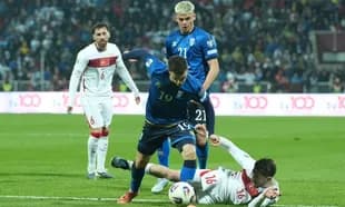 Player from team in blue challenging opponent on ground