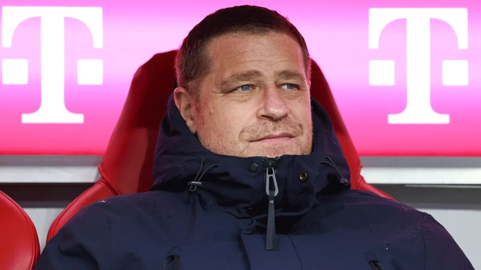 Coach seated on bench during match at stadium